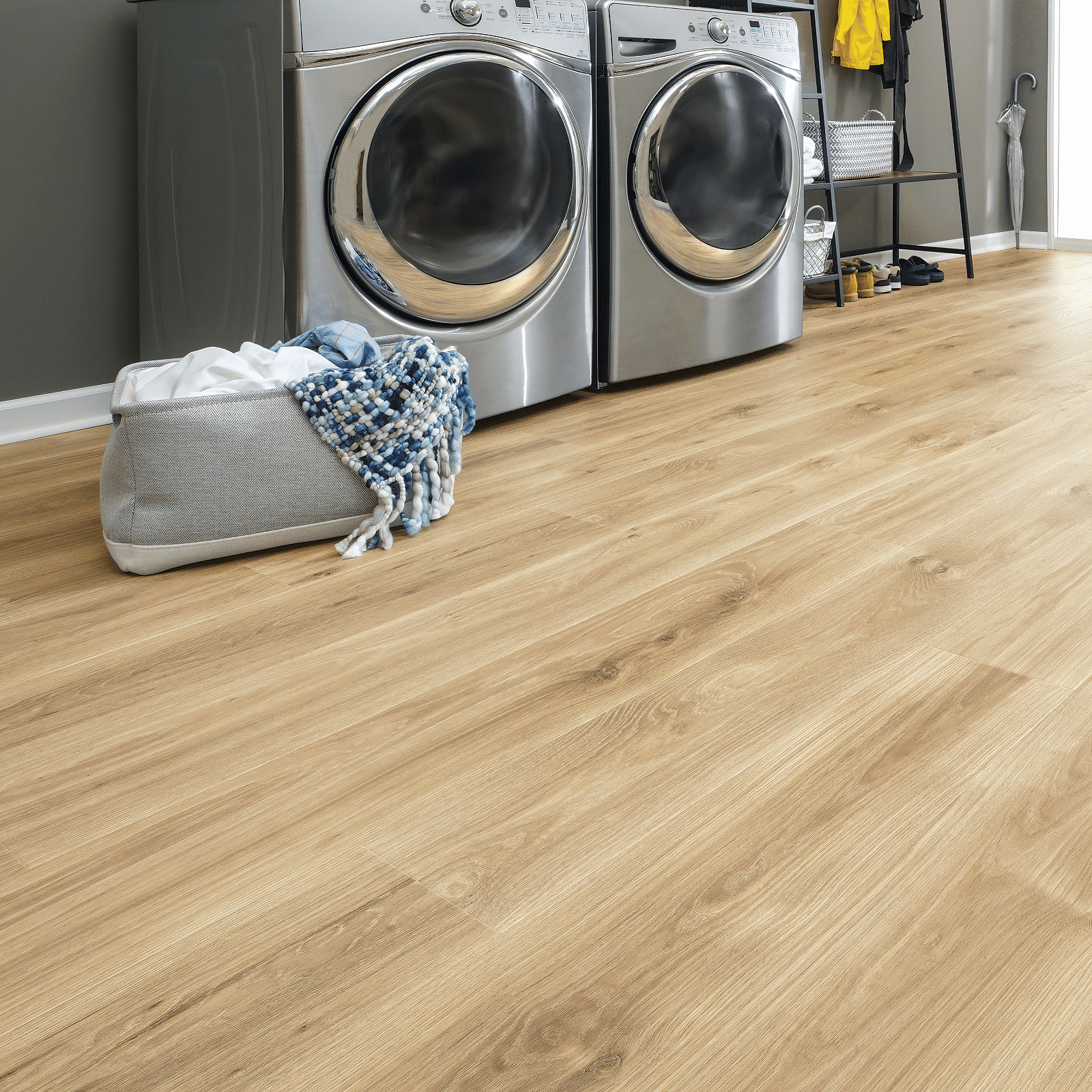 A laundry room with two machines and a bag.