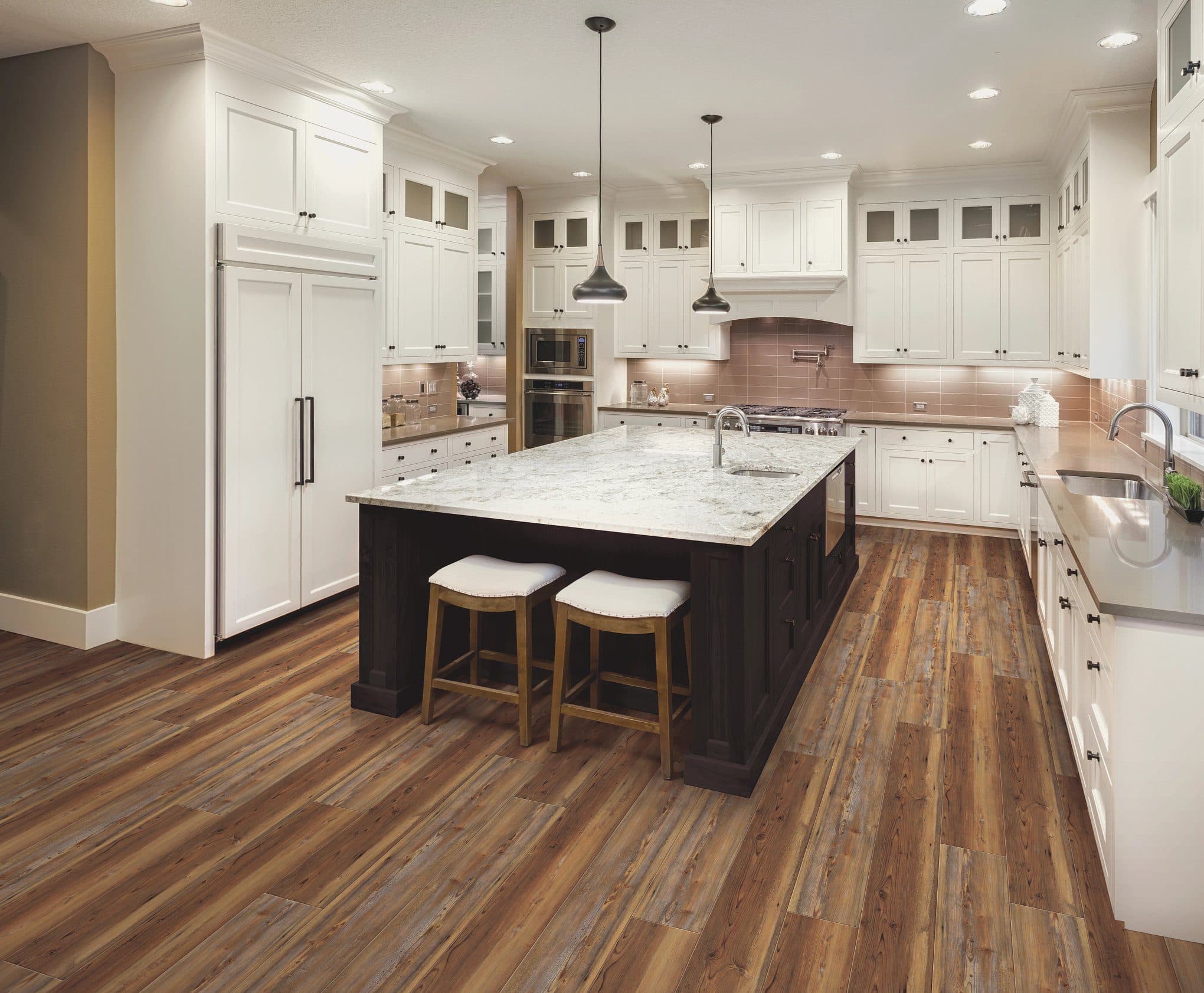A kitchen with white cabinets and wooden floors