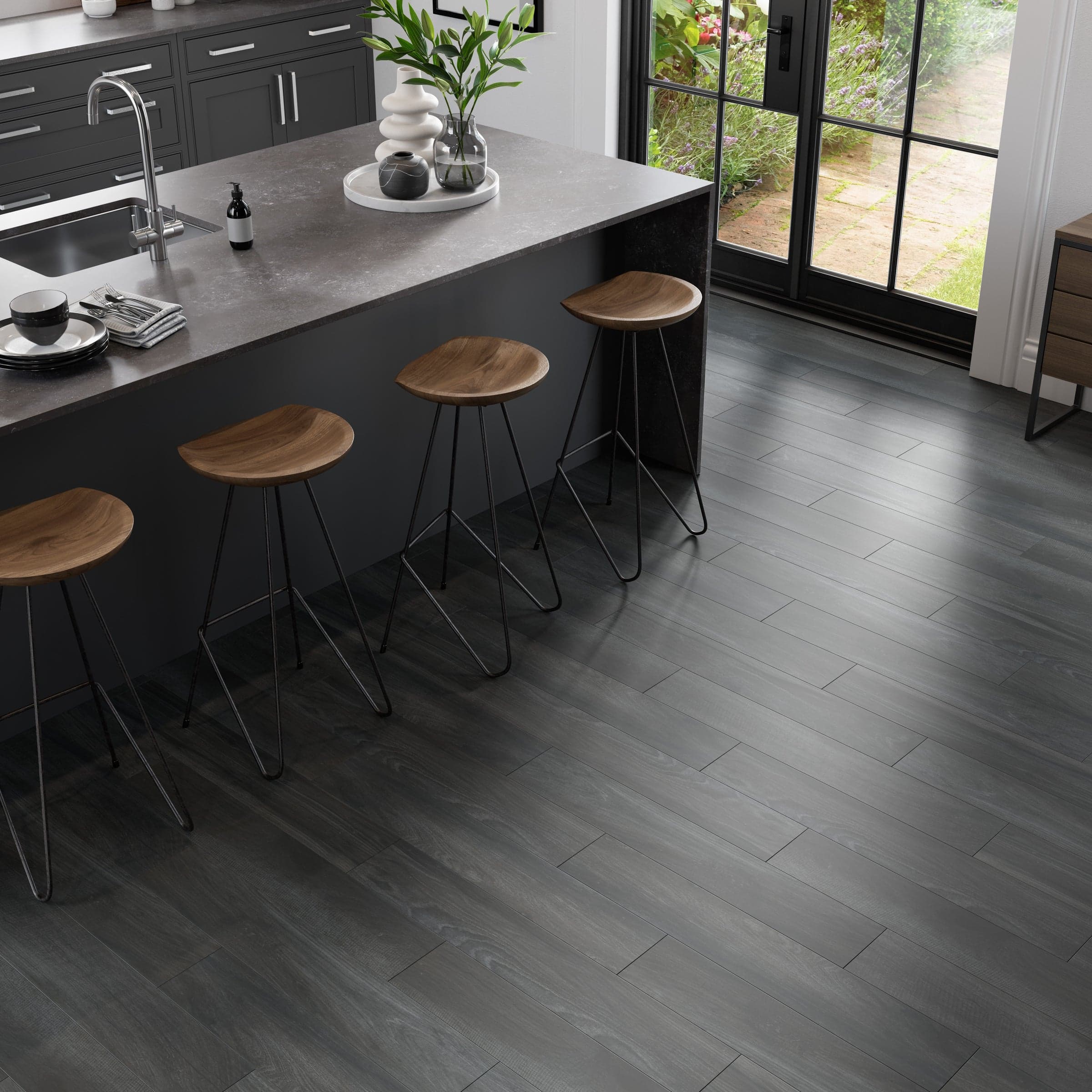 A kitchen with wooden floors and black cabinets