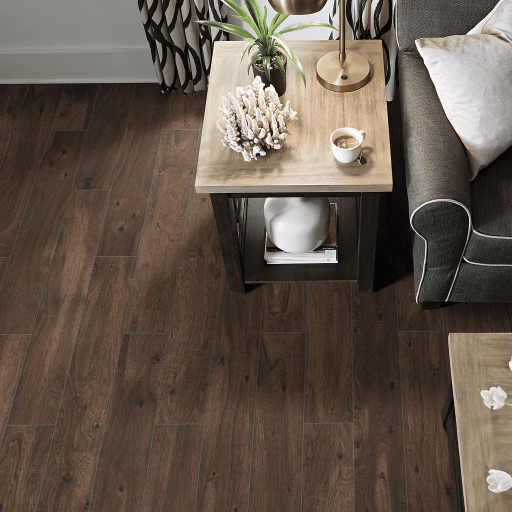A living room with brown wood floors and furniture.