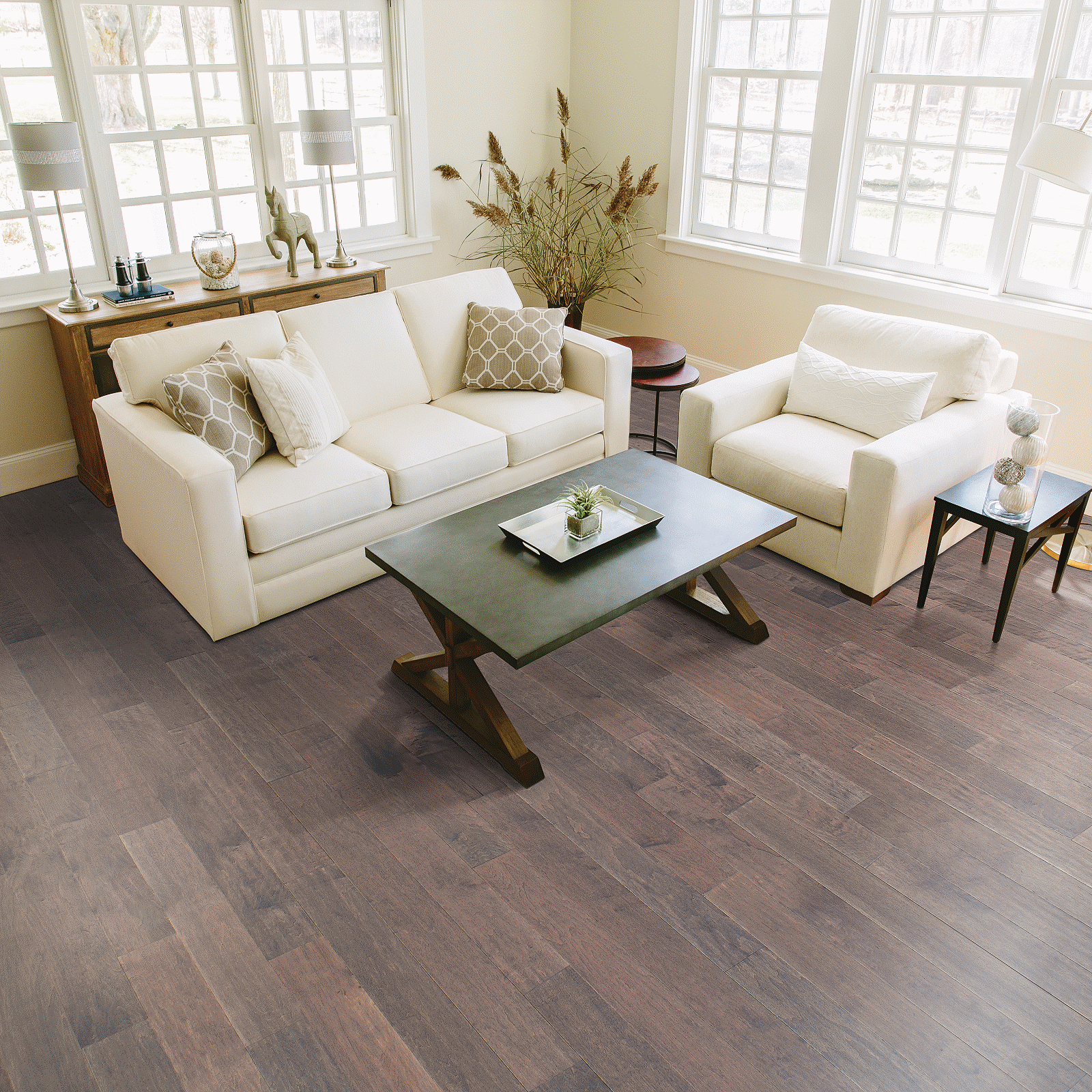 A living room with white furniture and large windows.