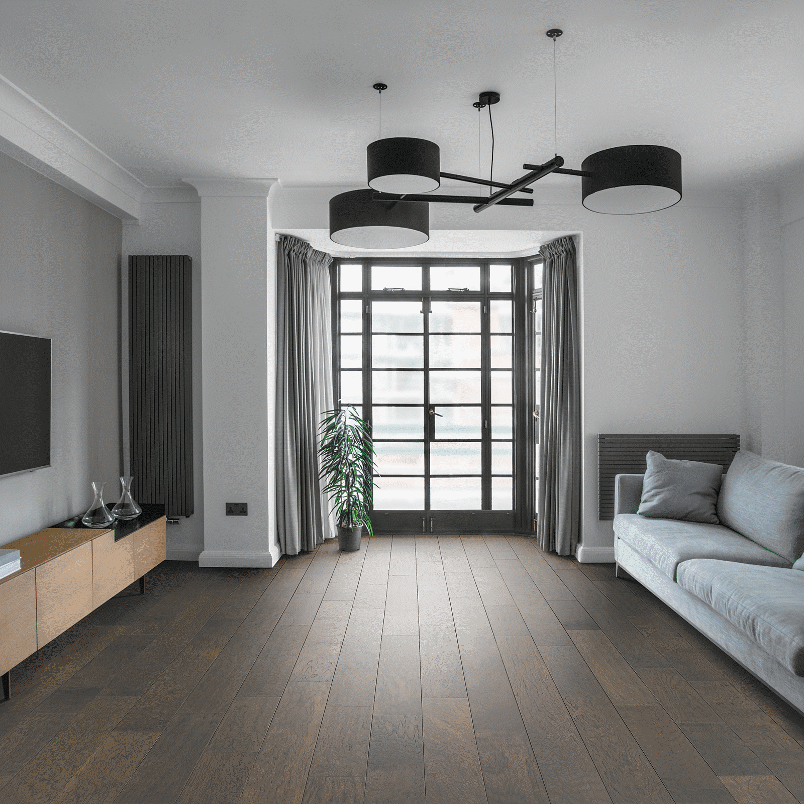 A living room with hardwood floors and white walls.
