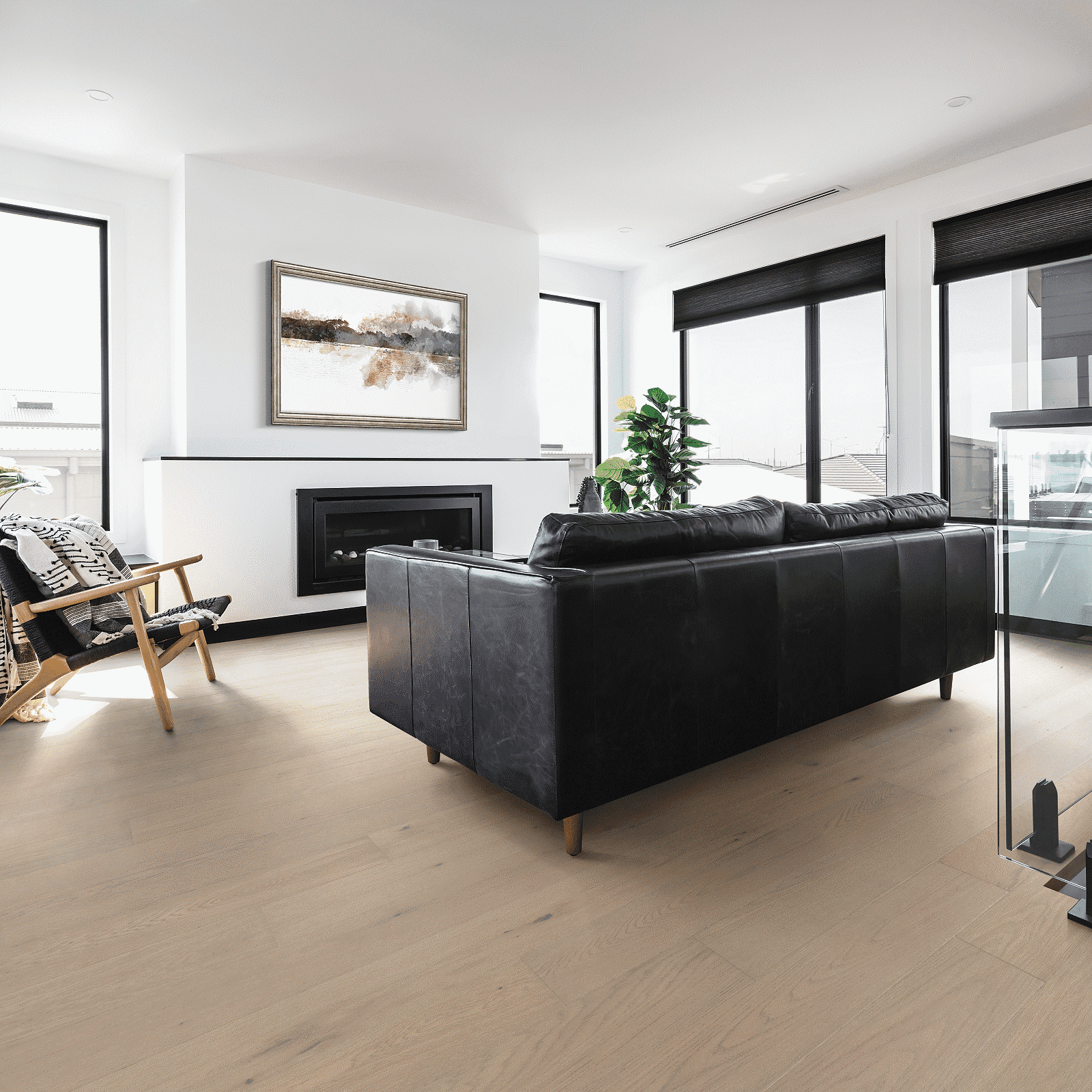 A living room with black leather furniture and white walls.