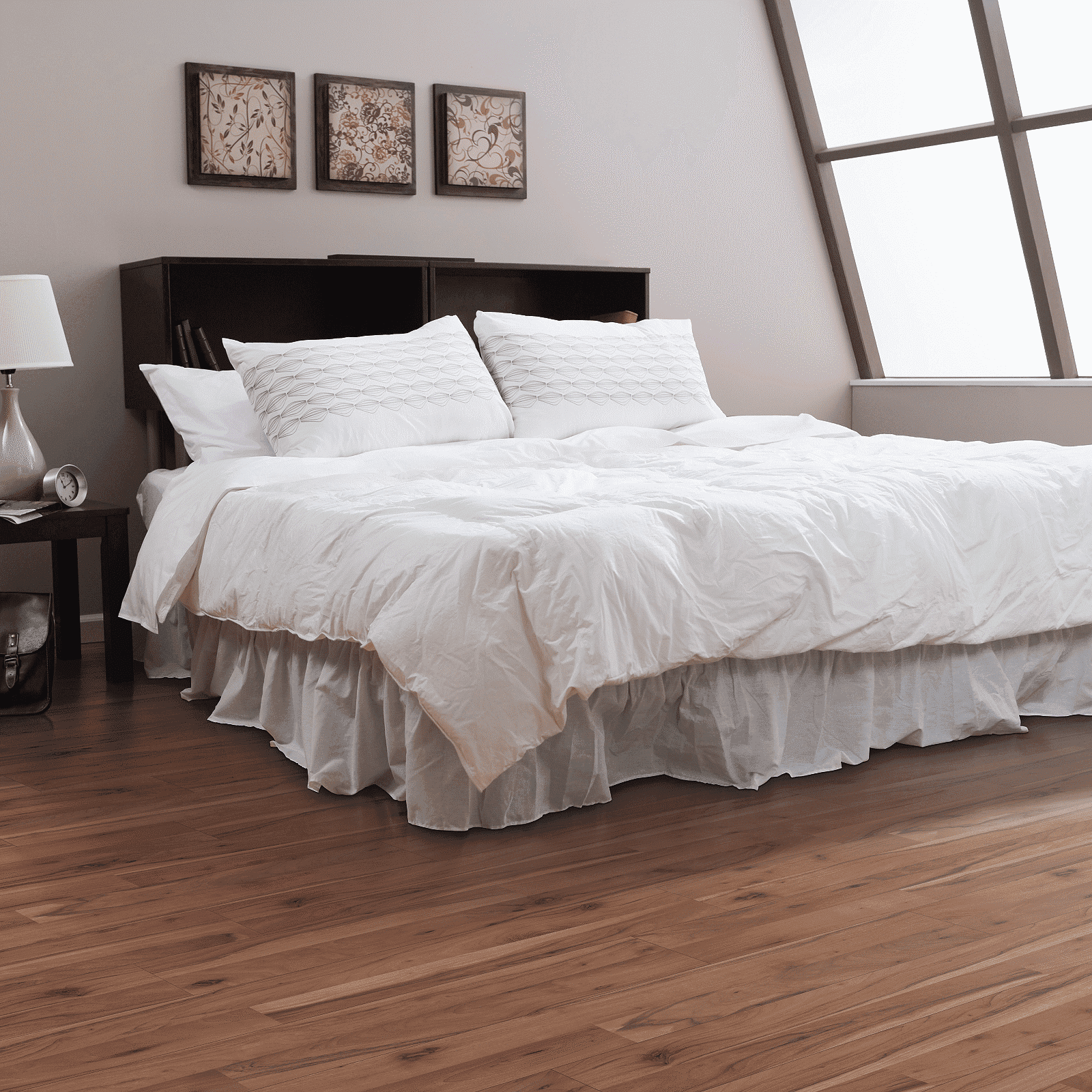 A bedroom with hardwood floors and white walls.