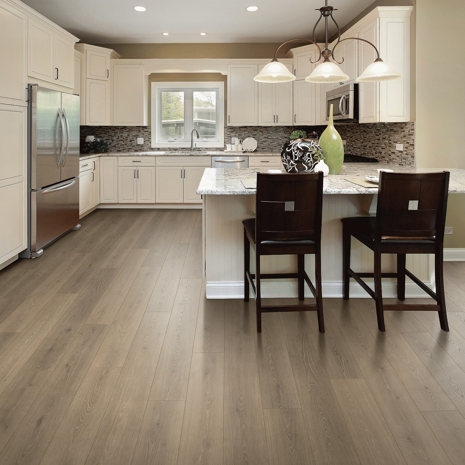 A kitchen with white cabinets and wooden floors.