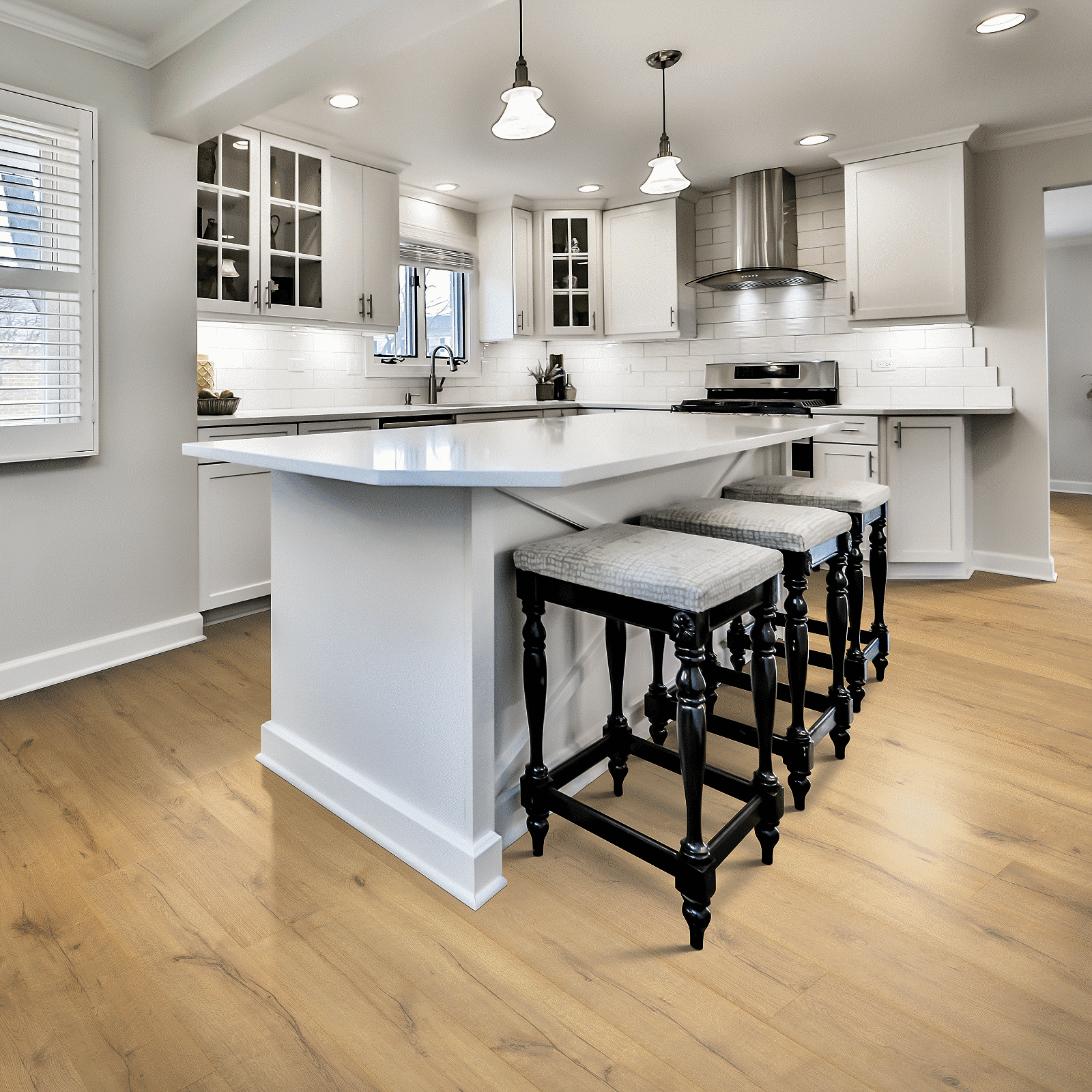 A kitchen with white cabinets and black stools.