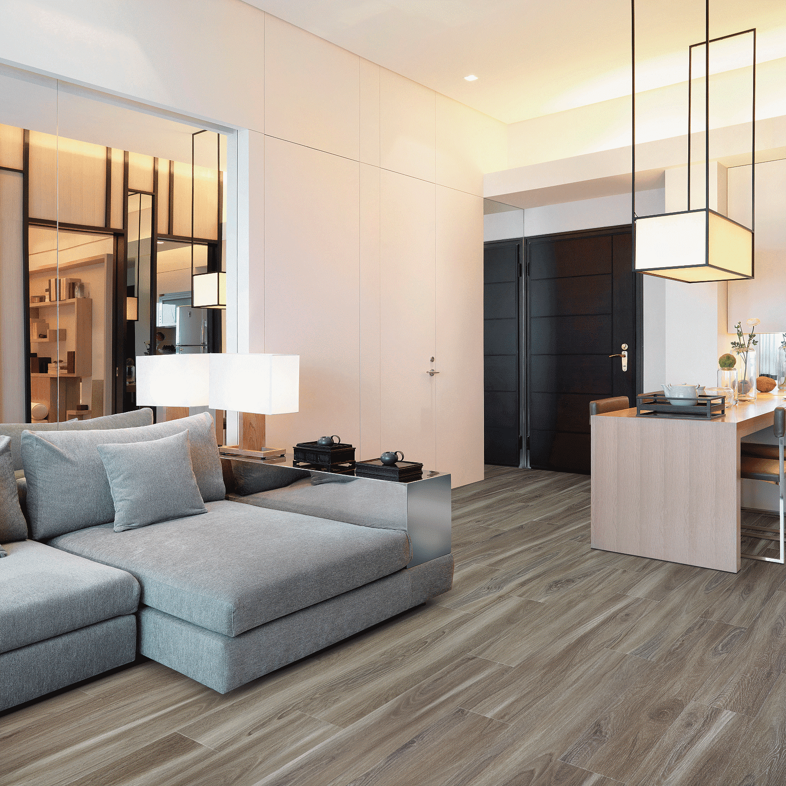 A living room with grey couches and white walls.