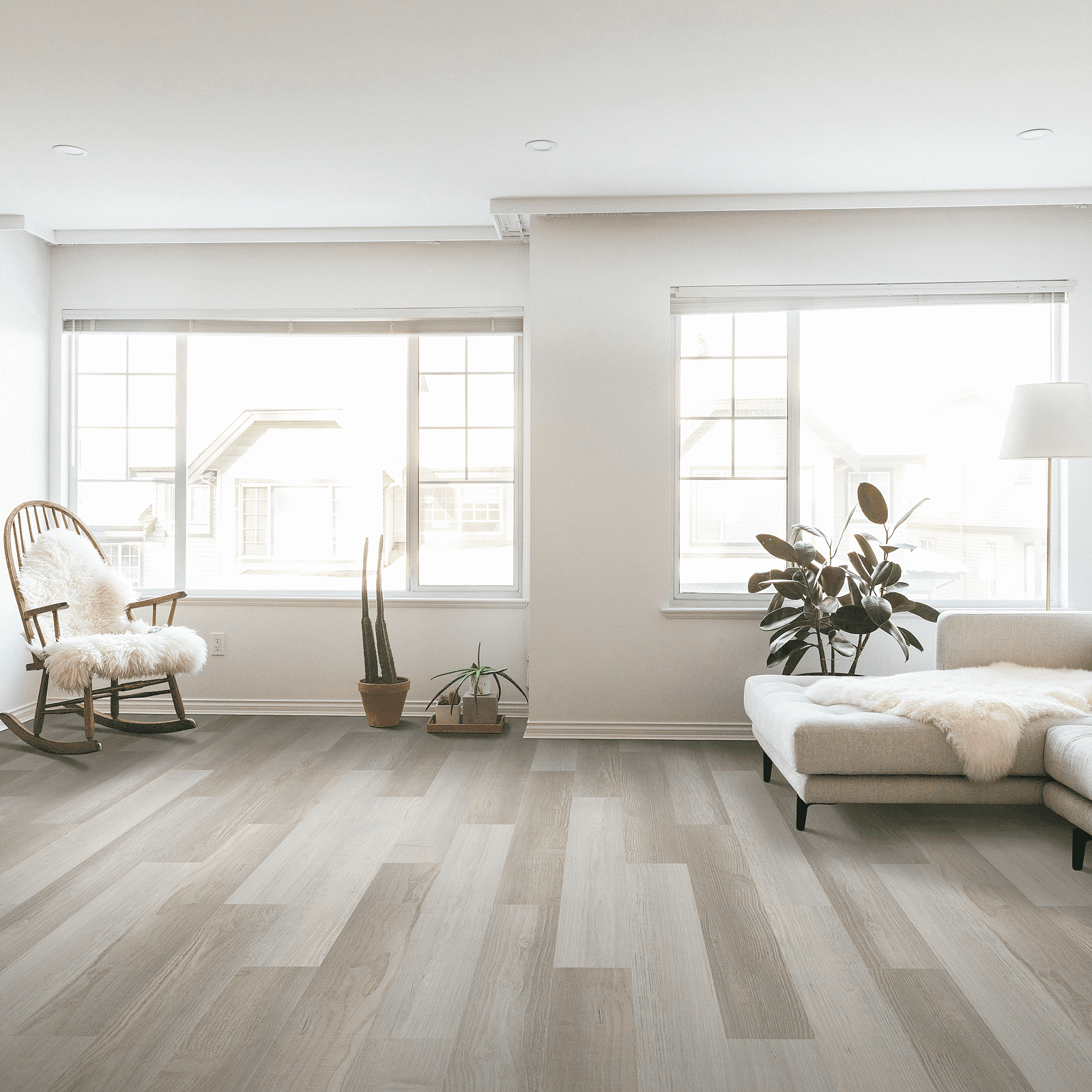 A living room with hard wood floors and large windows.