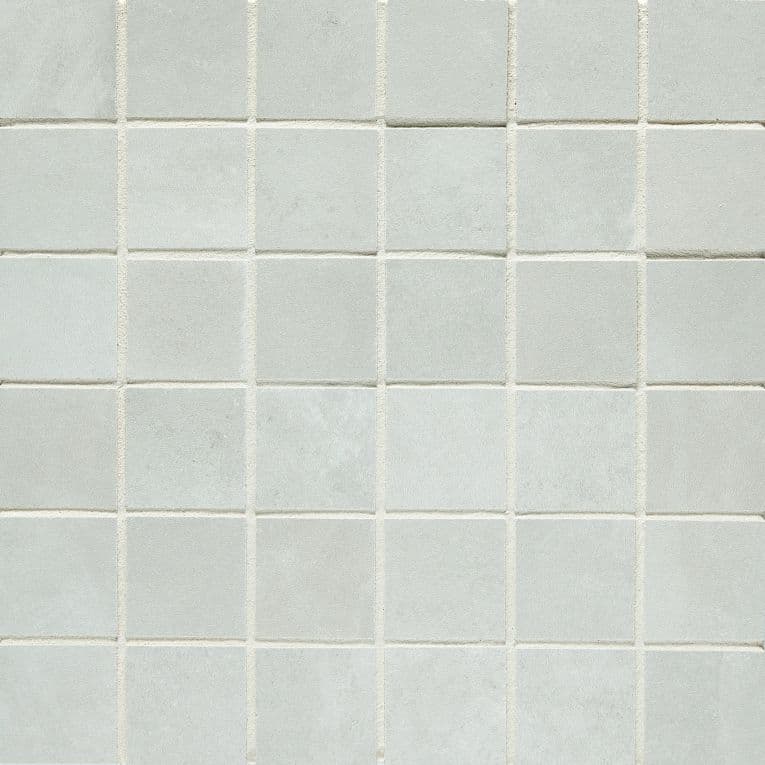 A white tile wall with some small squares