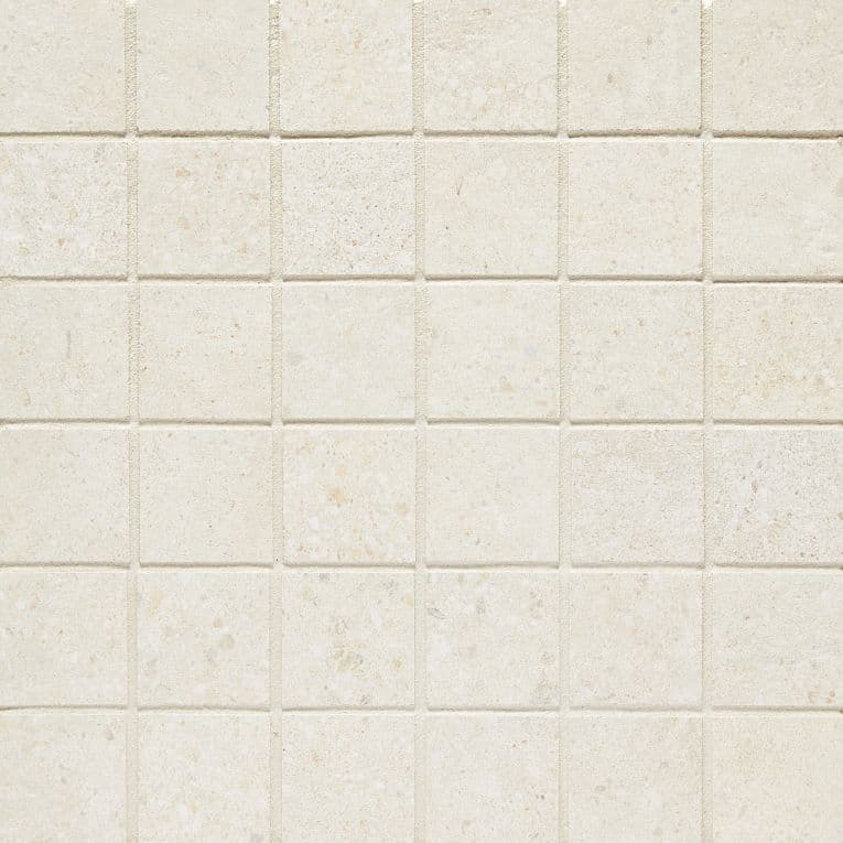A white tile wall with some small squares