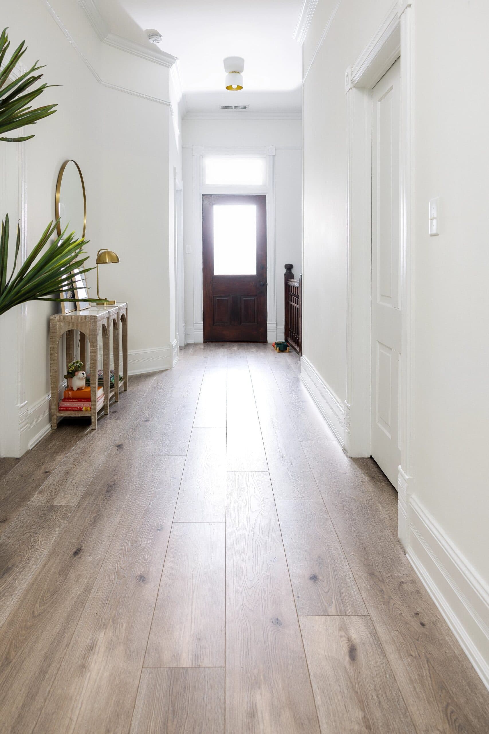 A hallway with wooden floors and white walls.