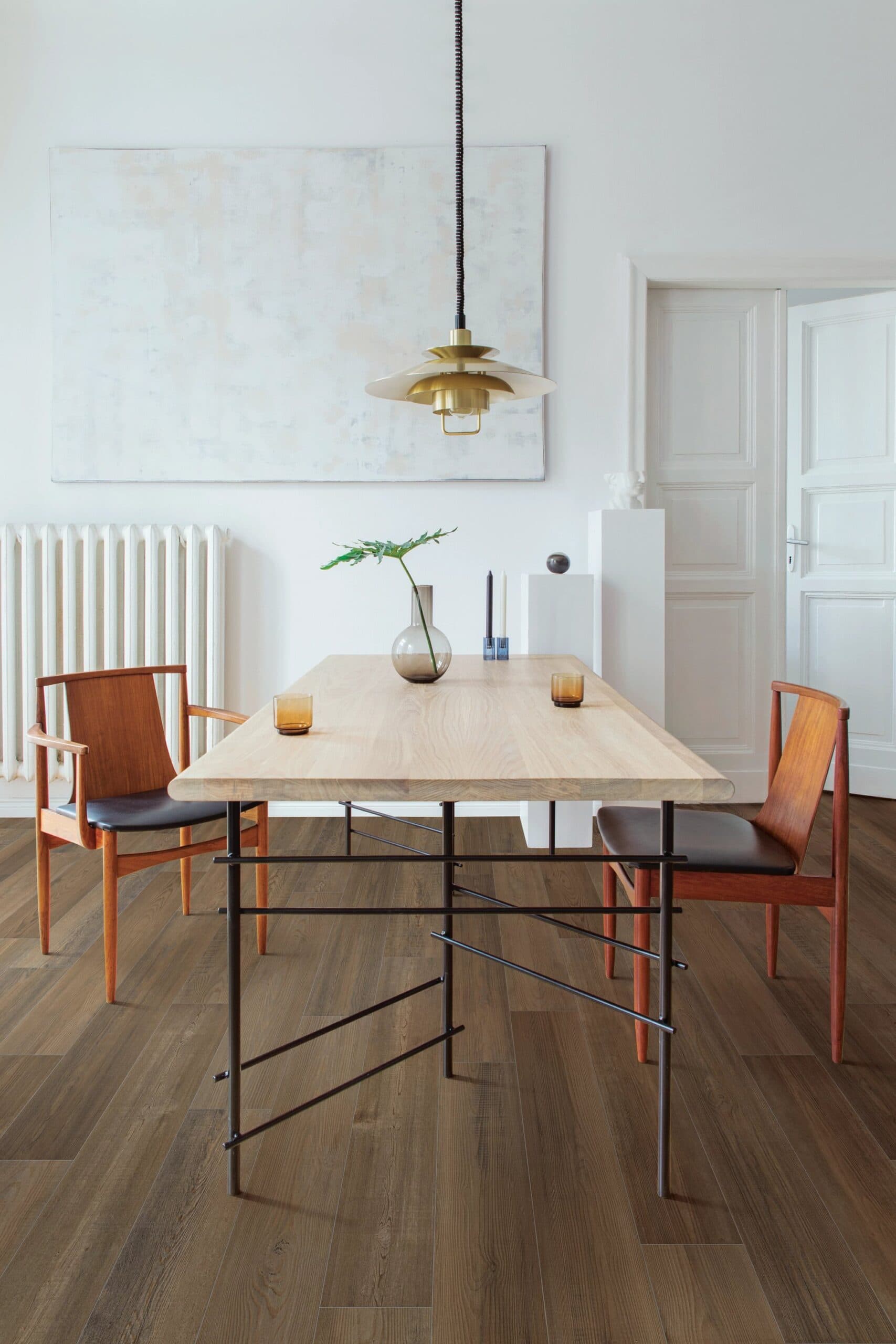 A dining room table with two chairs and a radiator