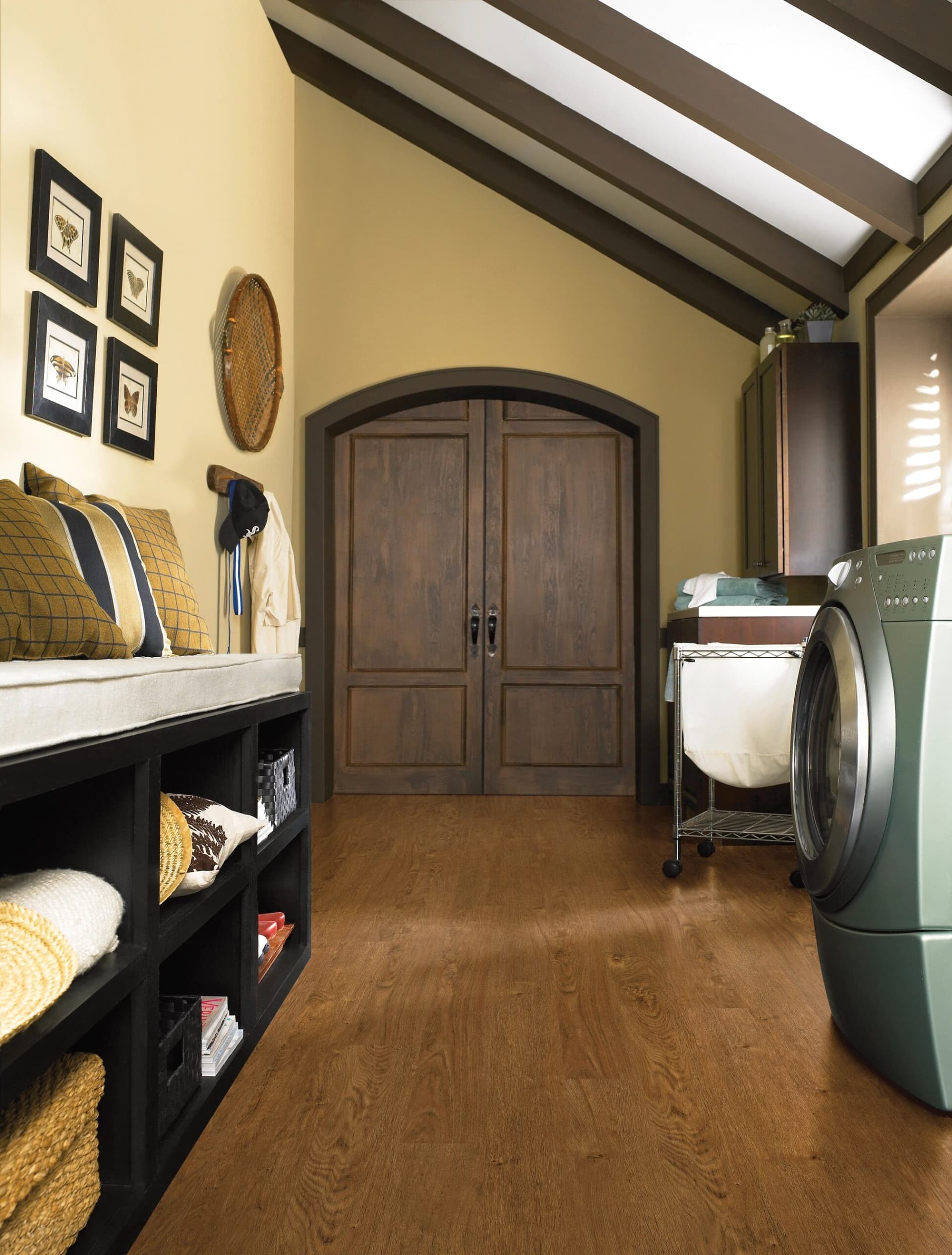 A room with a laundry machine and shelves.