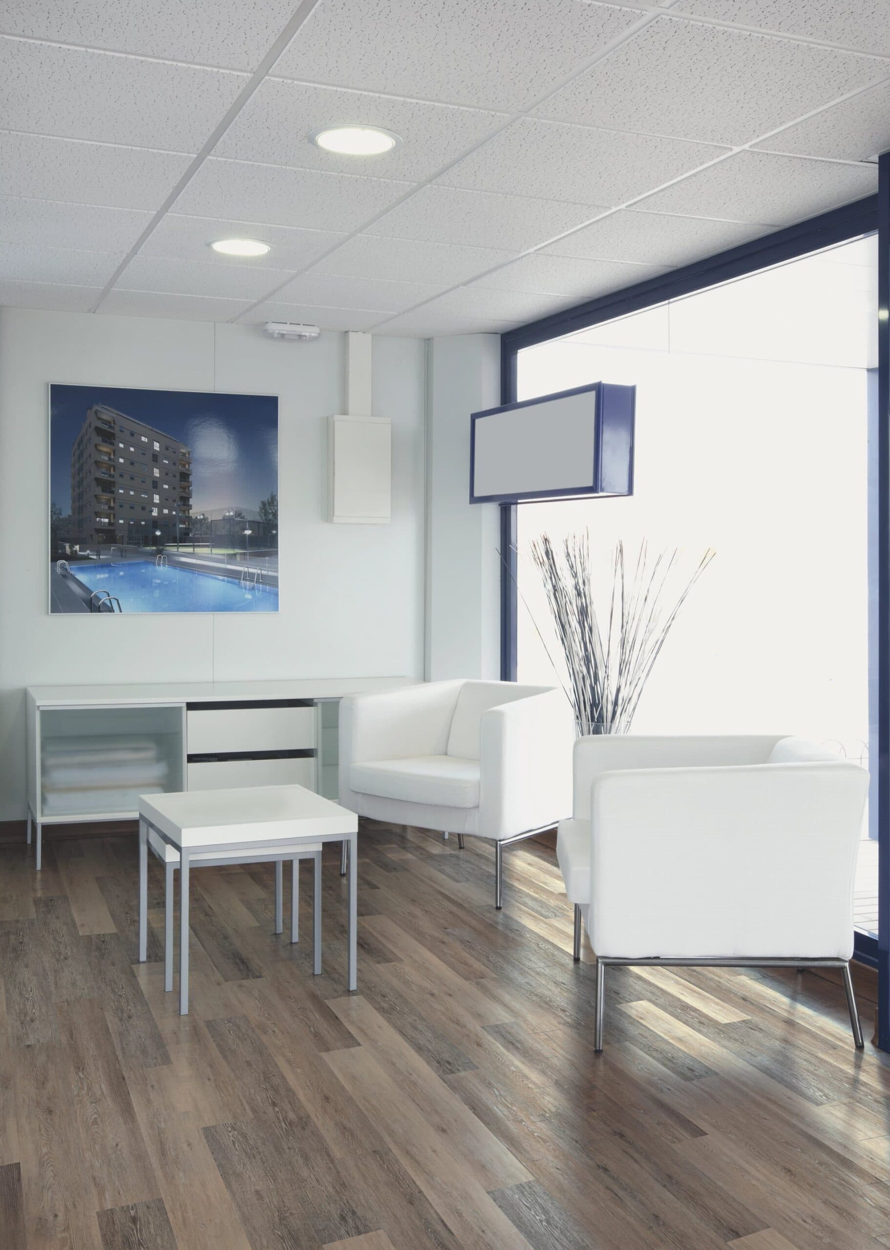 A room with white furniture and a large window.