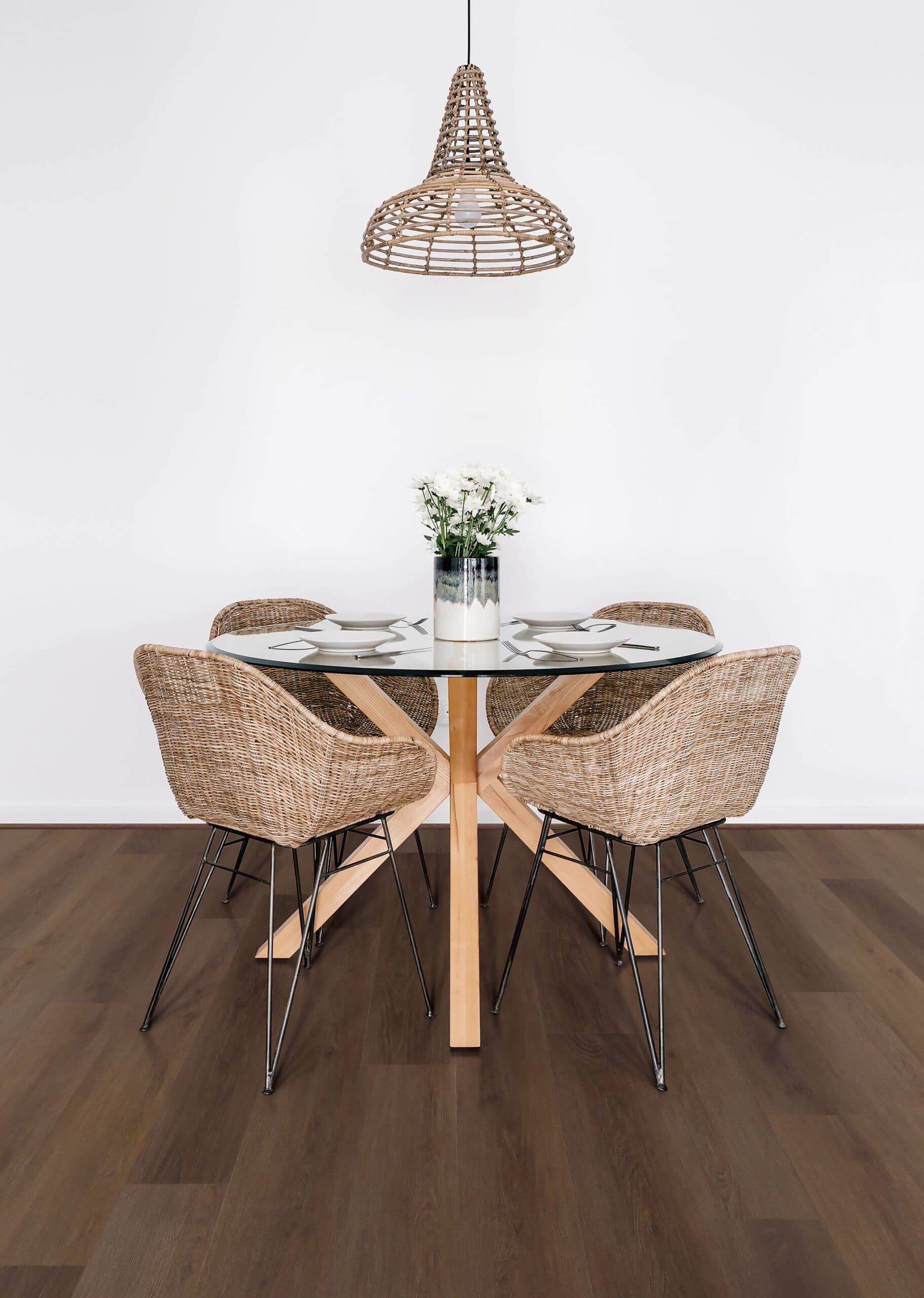 A table with four chairs and a lamp on the wall.