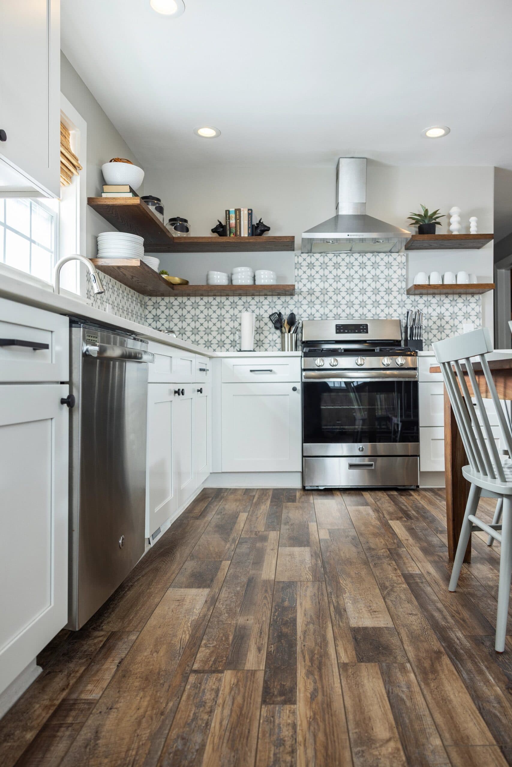 A kitchen with white cabinets and wooden floors