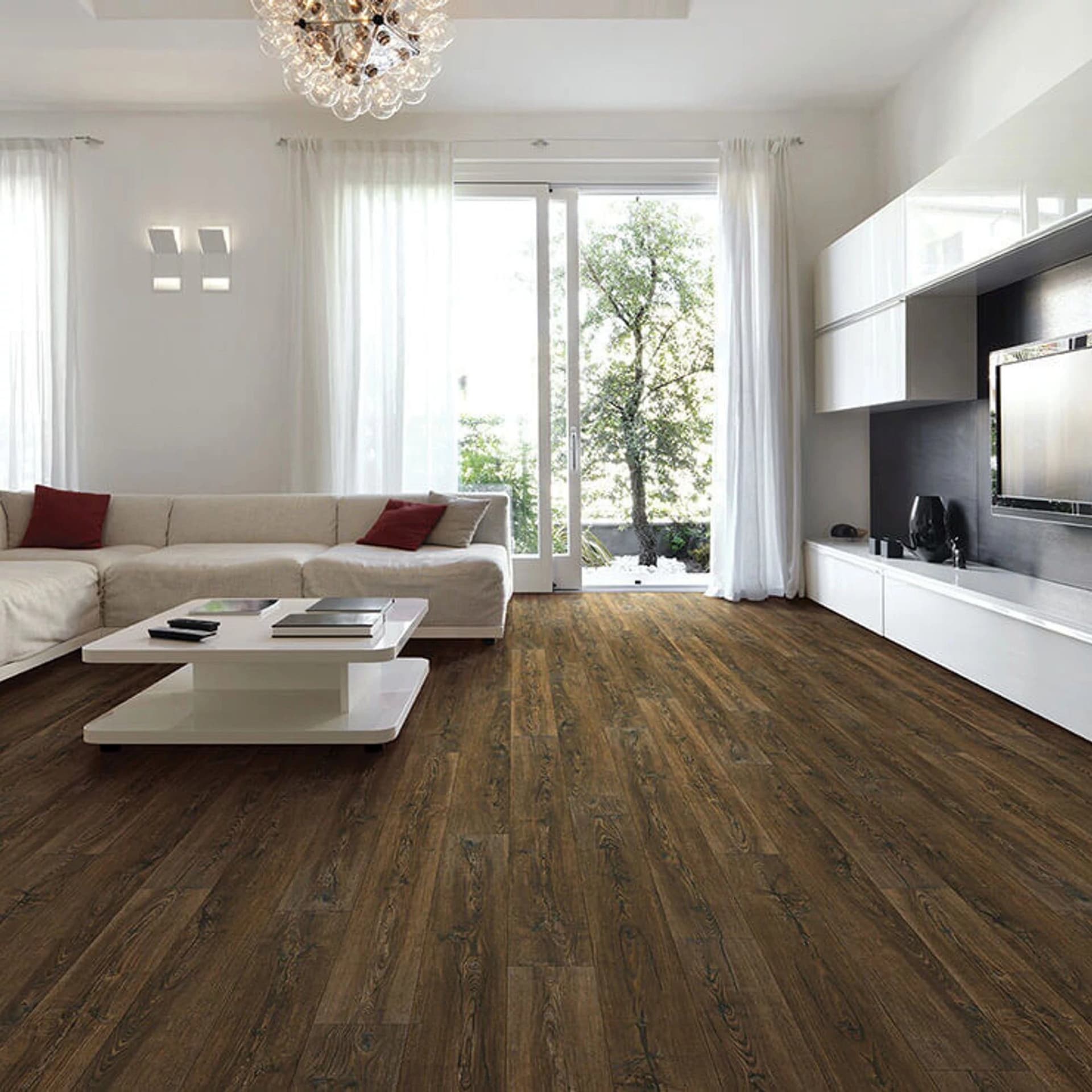 A living room with white walls and brown flooring.