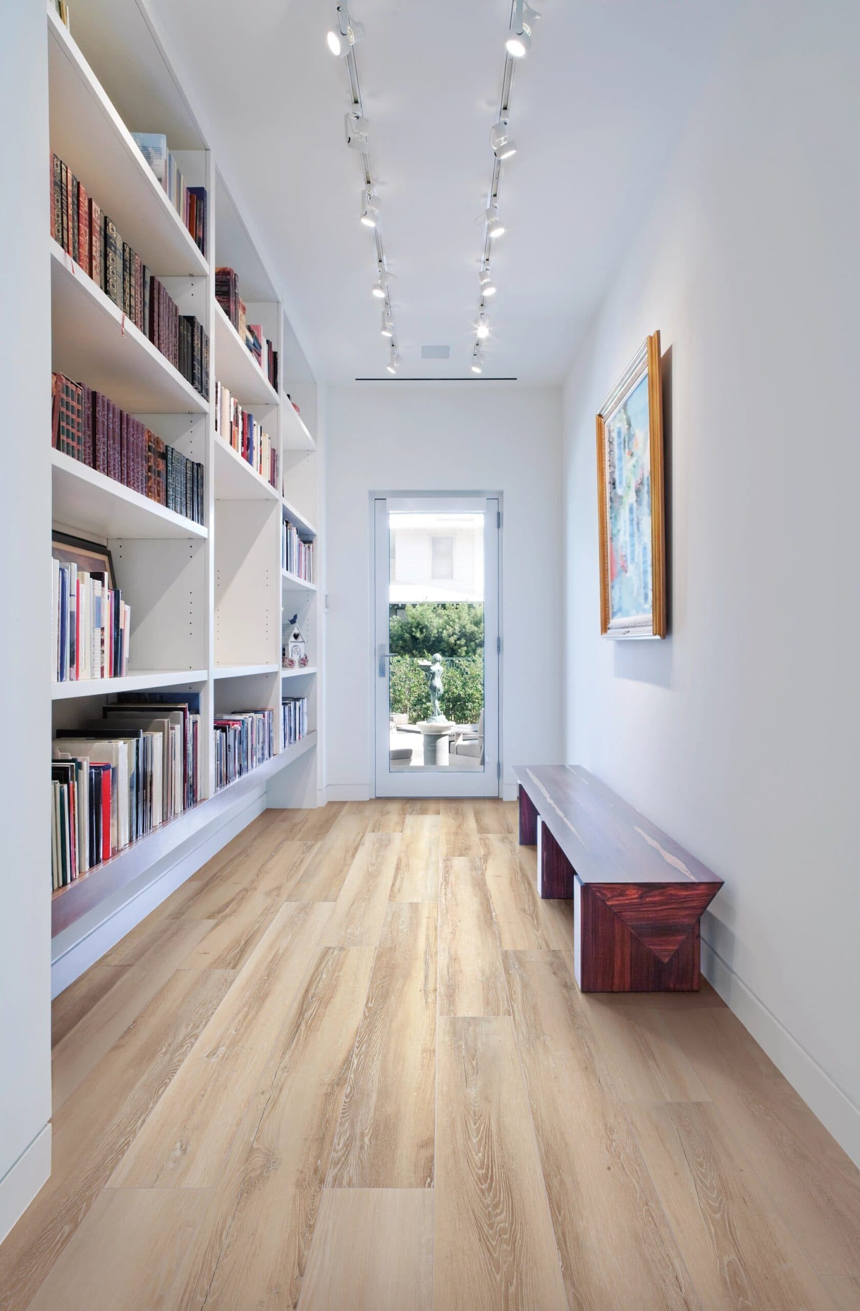 A hallway with bookcases and a bench in the middle.
