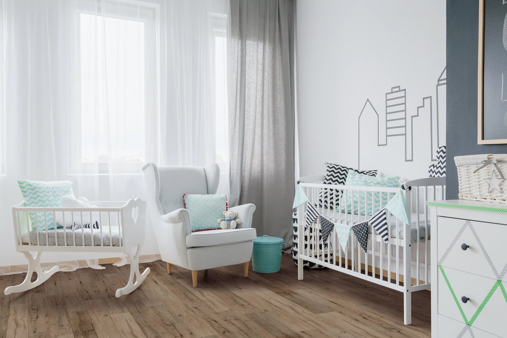 A baby room with a rocking chair and crib.