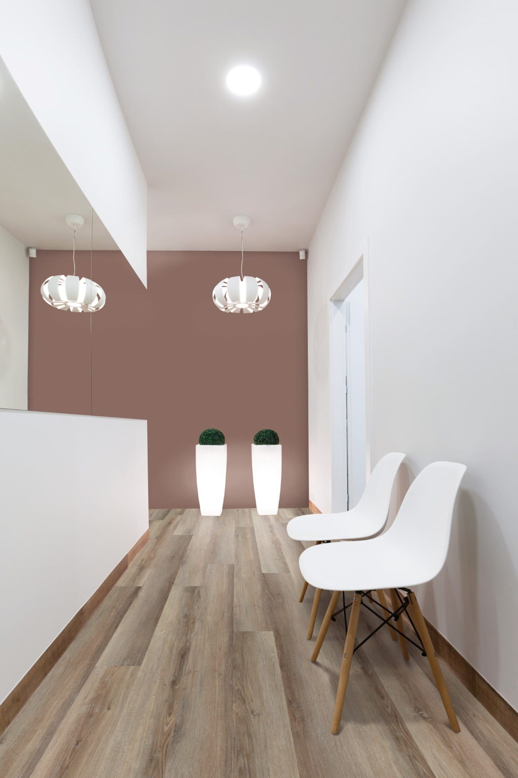 A room with two white chairs and a pink wall