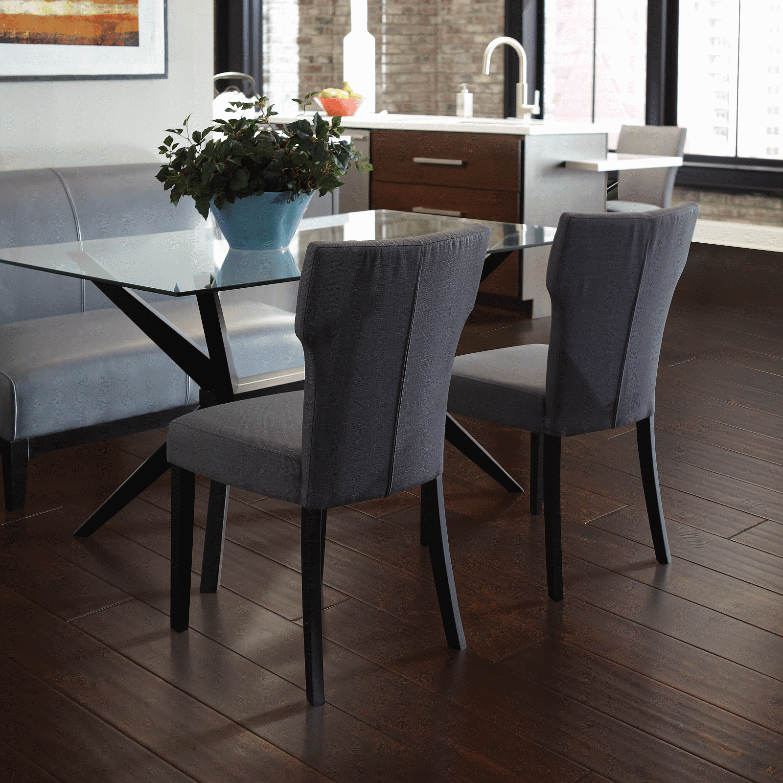 A dining room table with two chairs and a glass top table.