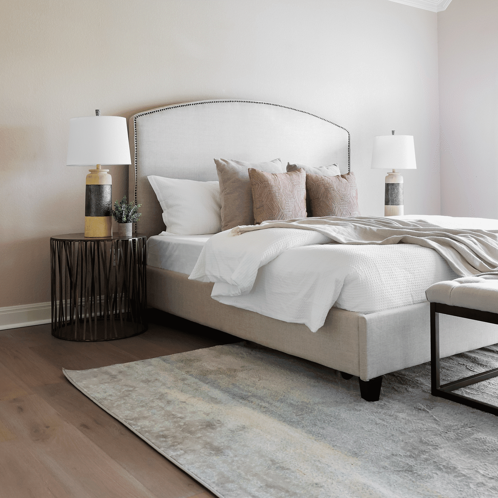 A bed room with a white bed and two lamps