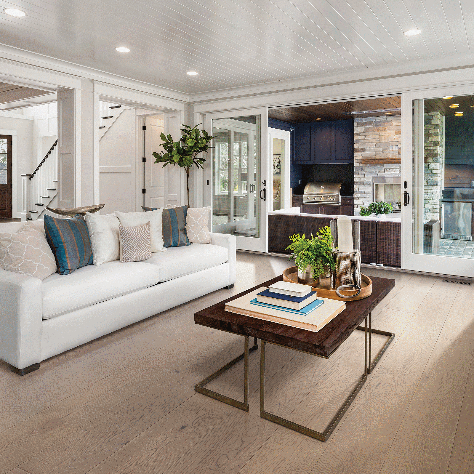 A living room with white furniture and wood floors.
