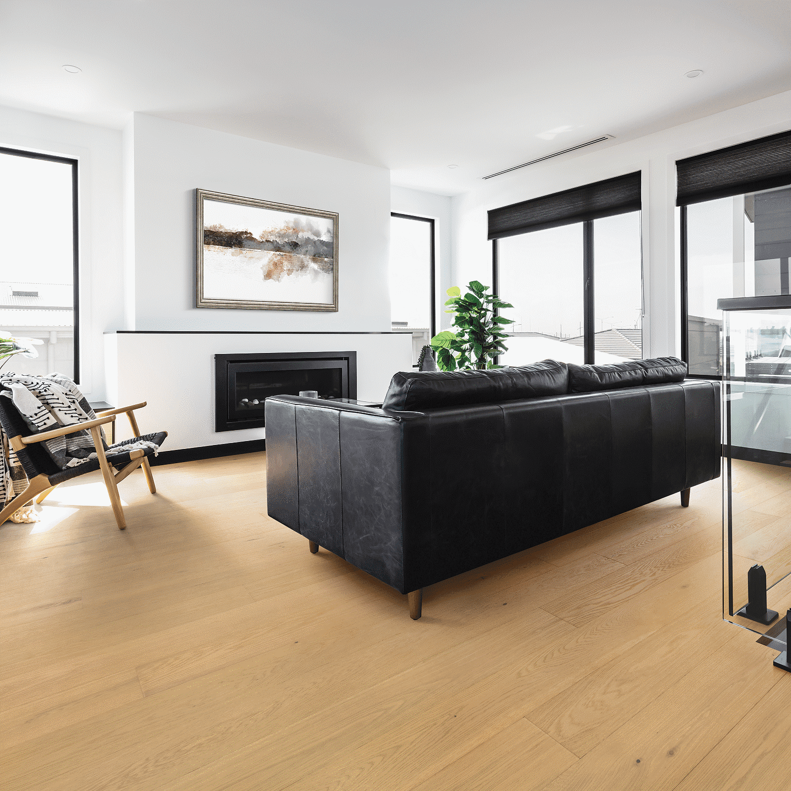 A living room with black leather furniture and white walls.