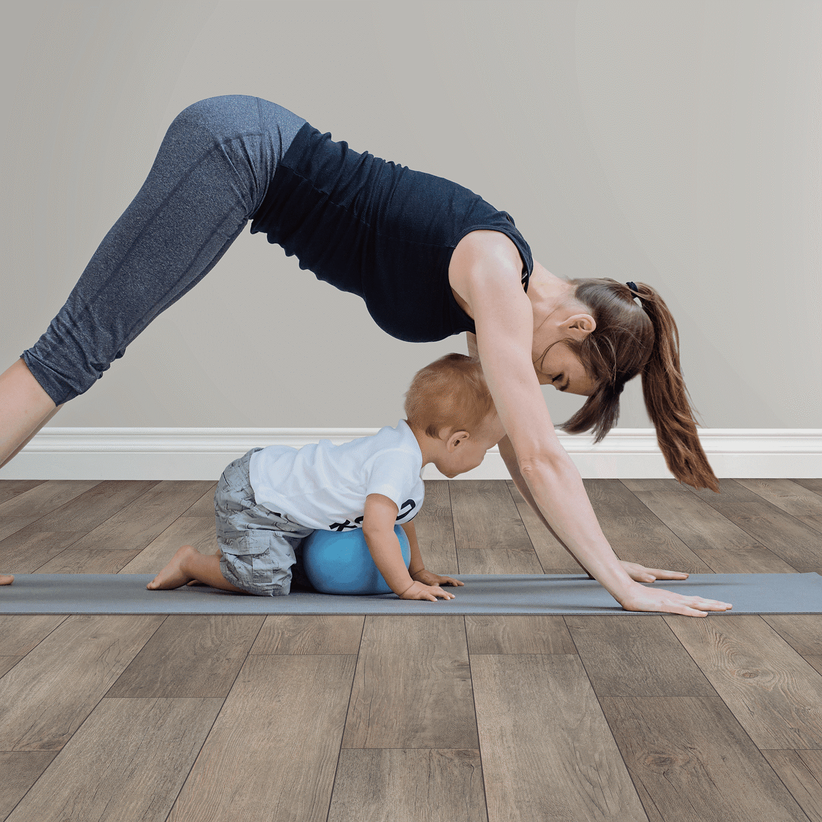 A woman and child doing yoga on the floor.