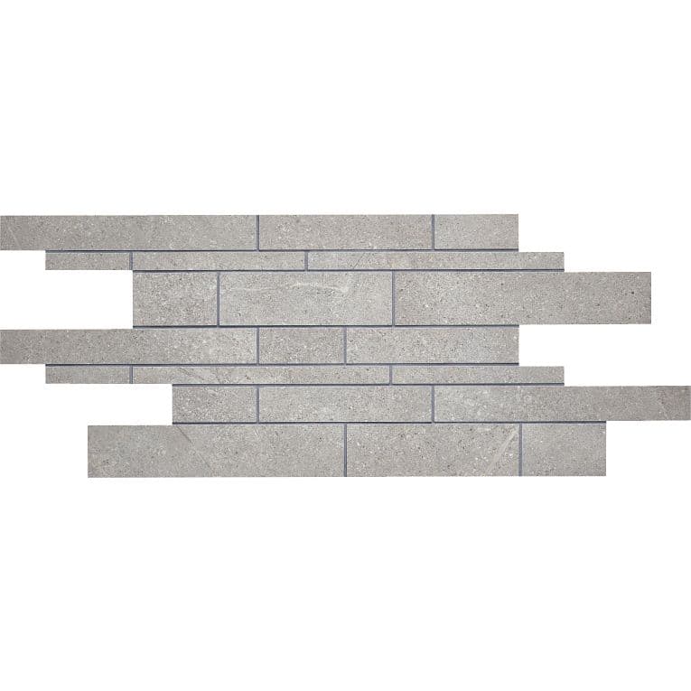 A gray brick wall with a strip of white bricks on it.