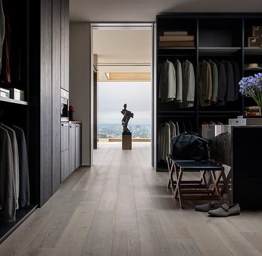 A walk in closet with black cabinets and a view of the ocean.