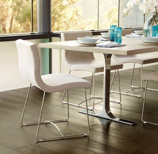 A white table and chairs in front of a window.