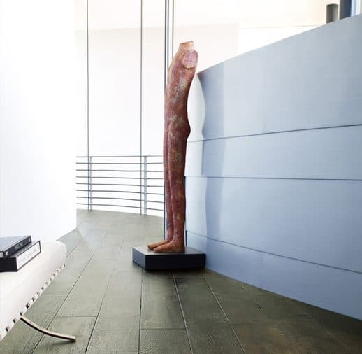 A sculpture of a person leaning against the wall