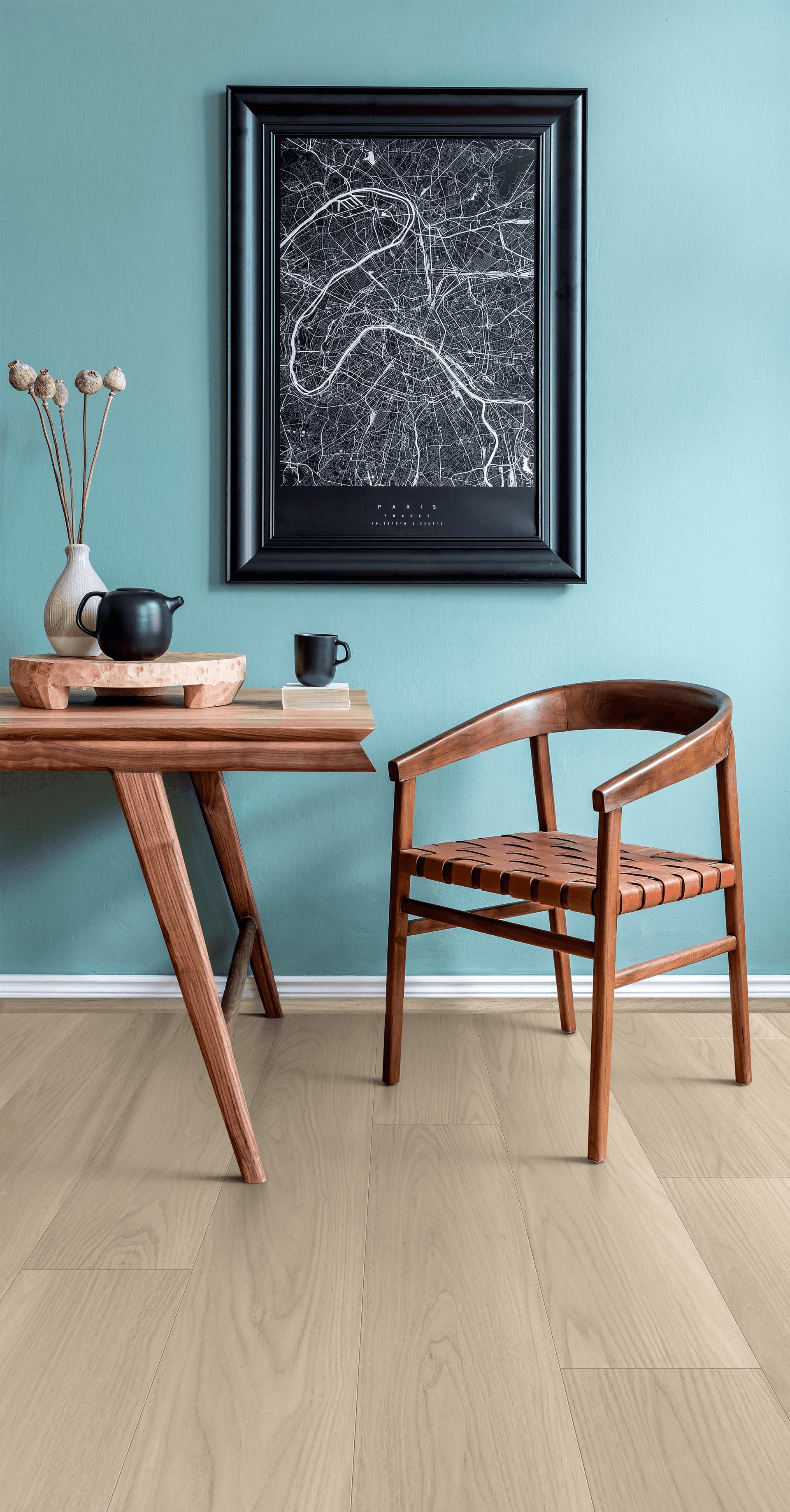 A table and chair in front of a wall with a picture on it.
