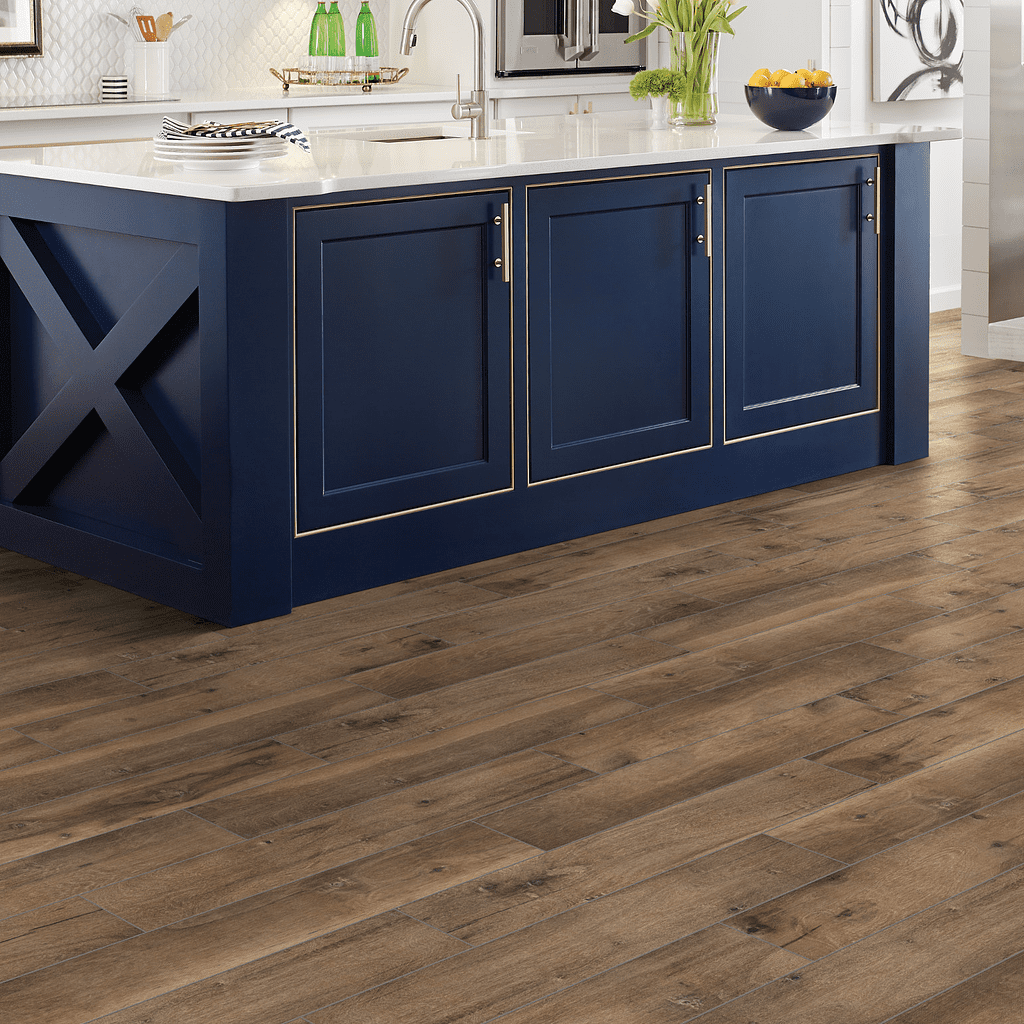 A kitchen with blue cabinets and wood floors.