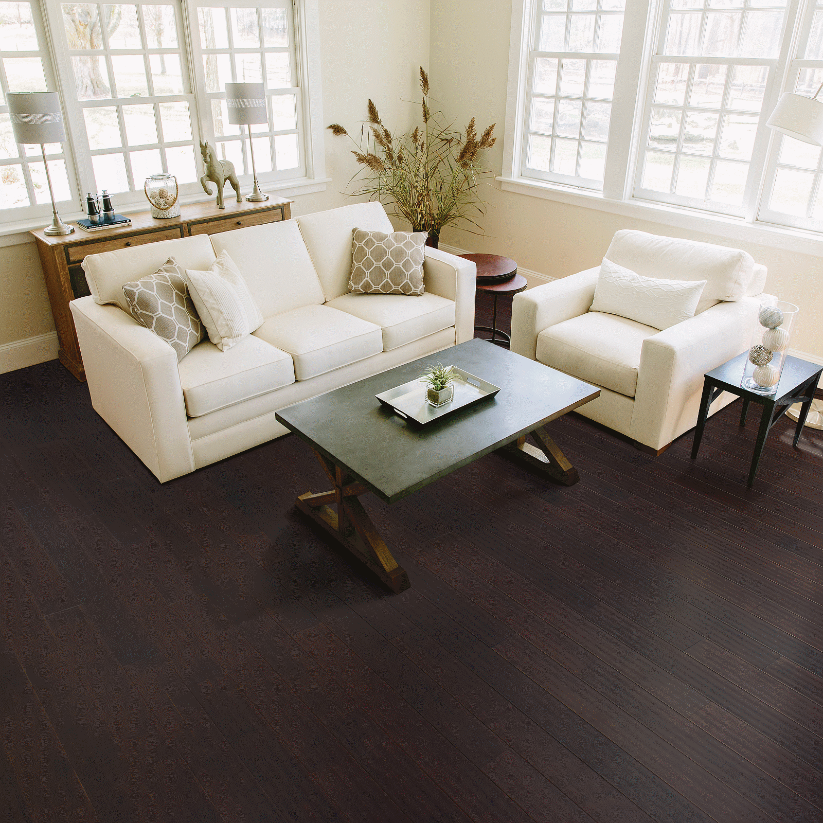 A living room with white furniture and large windows.