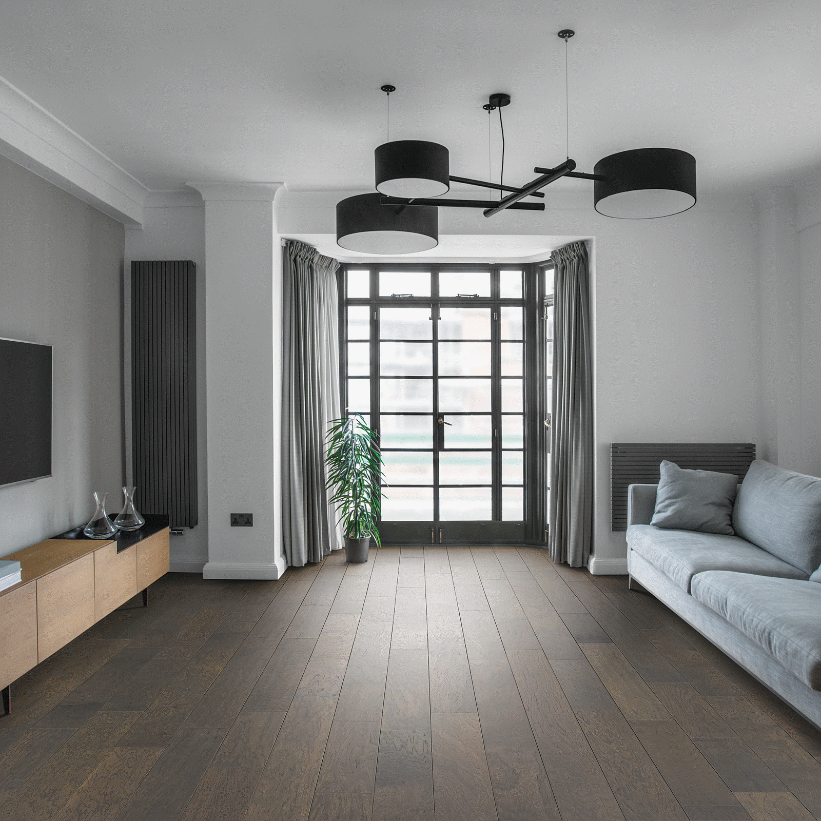 A living room with hardwood floors and white walls.