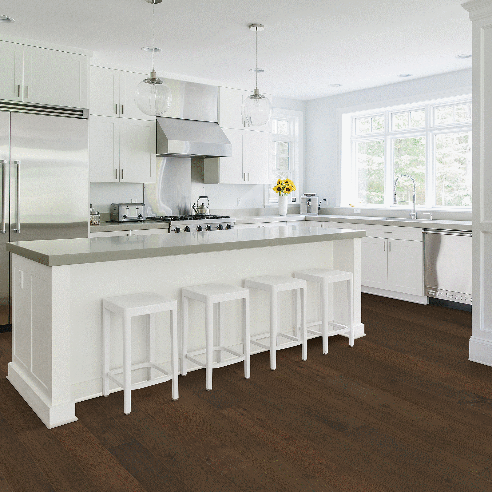 A kitchen with white cabinets and brown floor