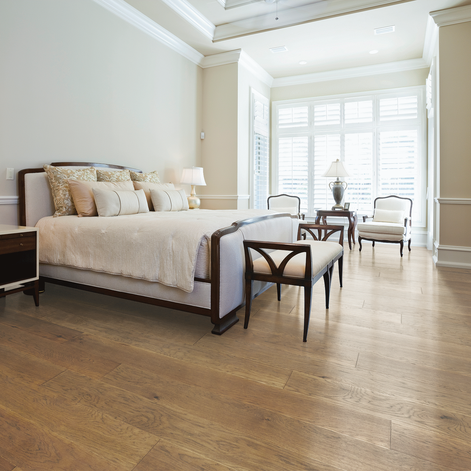 A bedroom with hard wood floors and white walls.