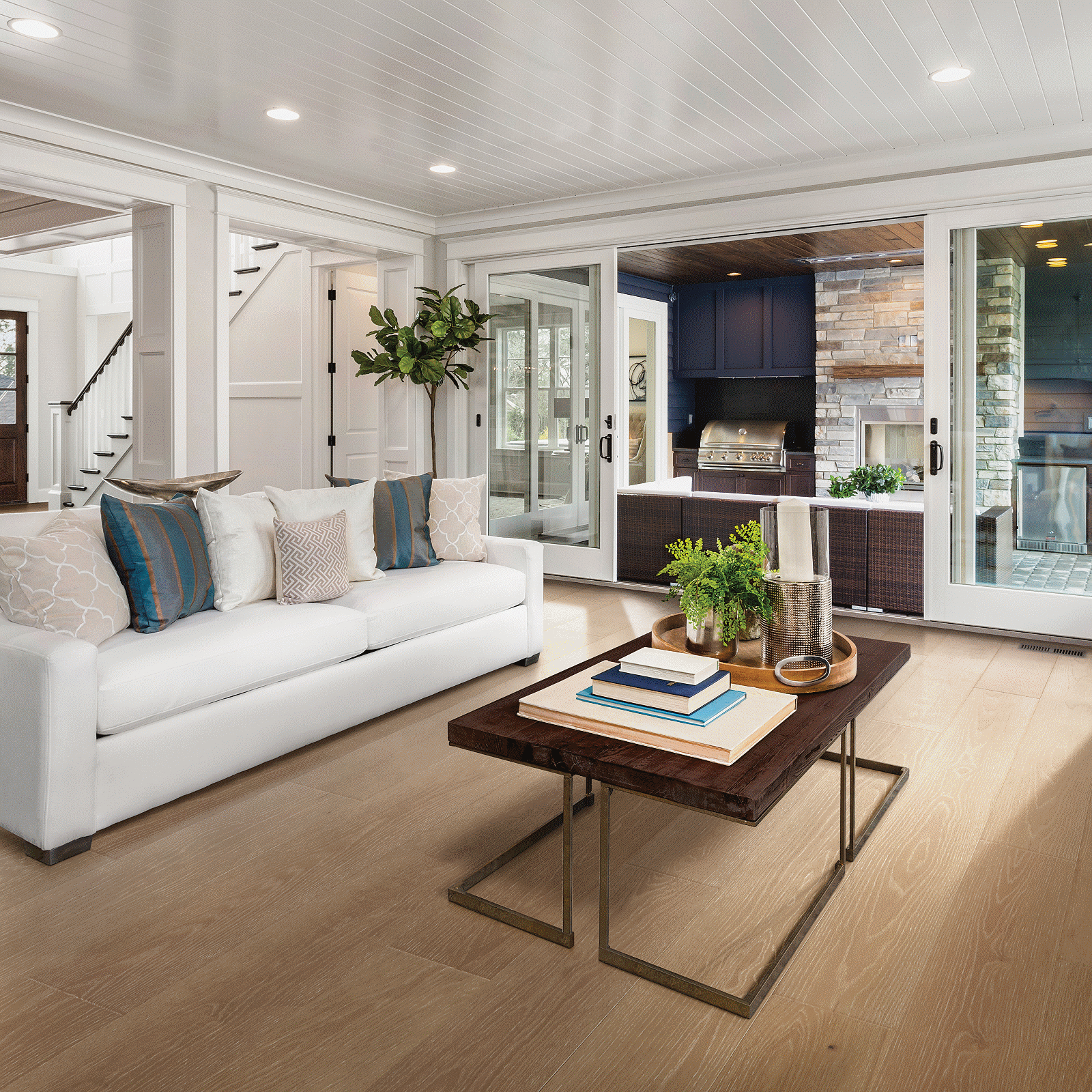 A living room with white furniture and wood floors.