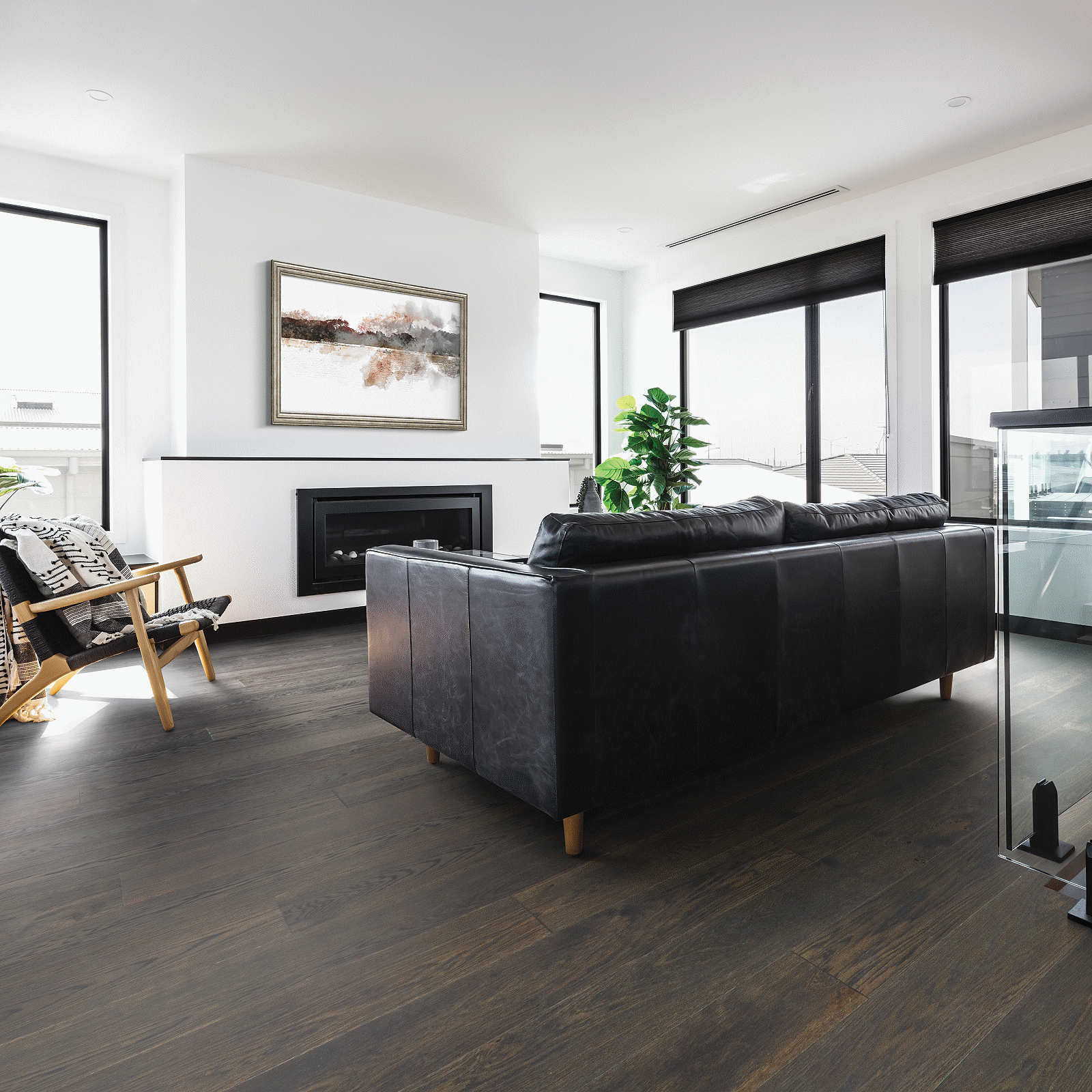 A living room with black furniture and white walls.