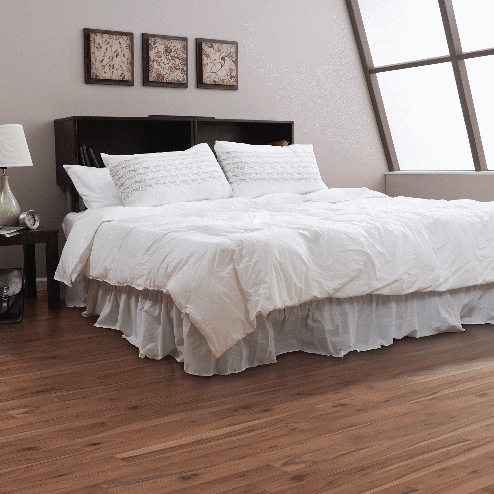 A bedroom with hardwood floors and white walls.