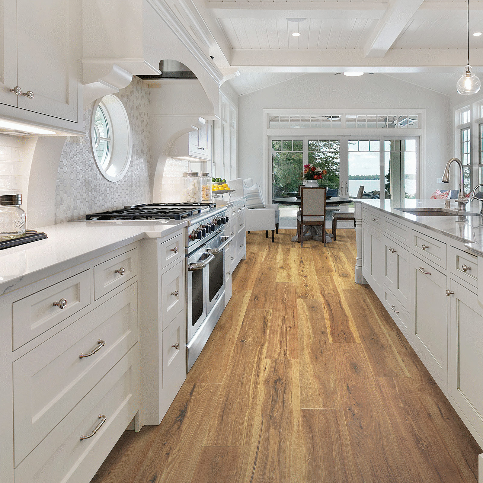 A kitchen with white cabinets and wood floors.