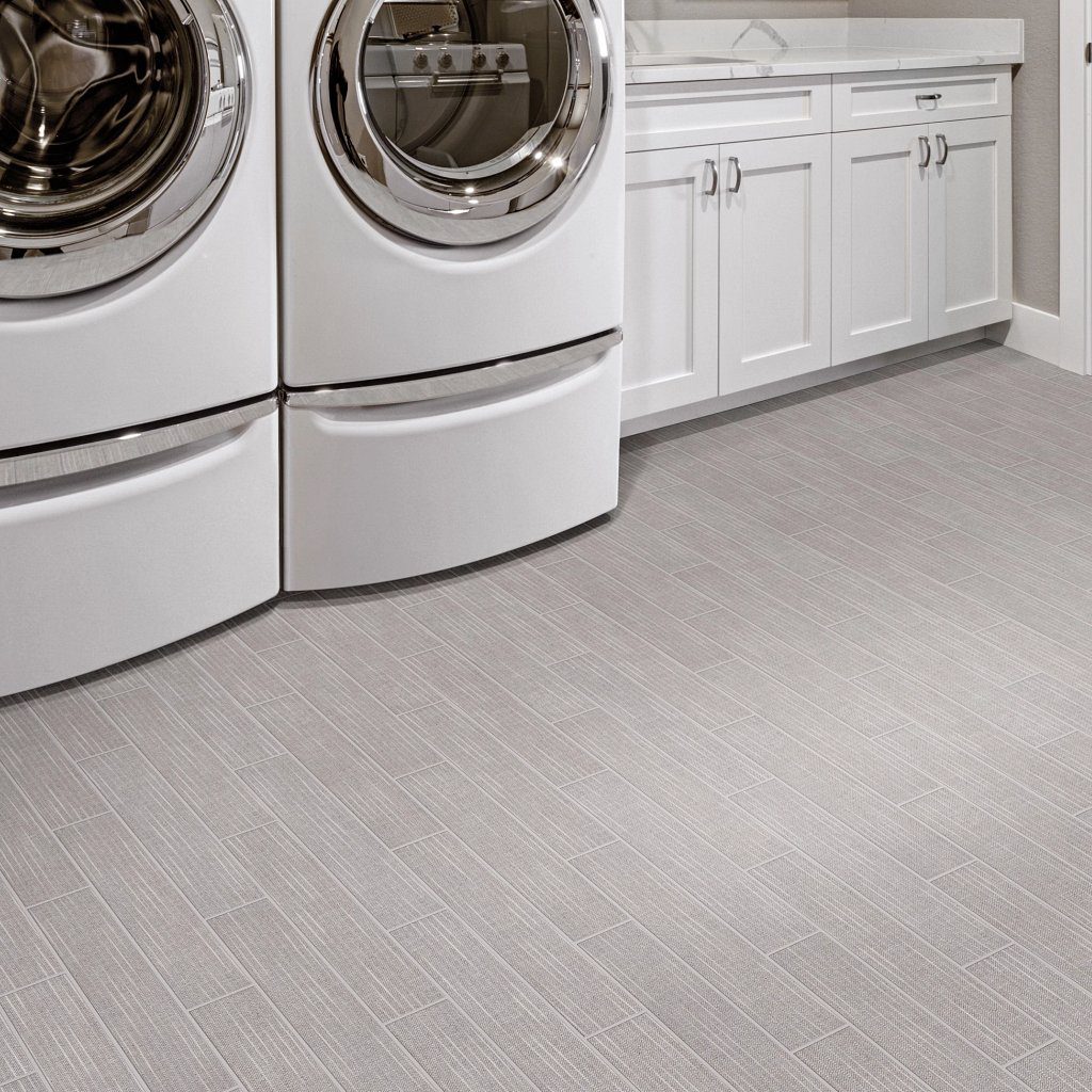 A white laundry room with two machines and cabinets.