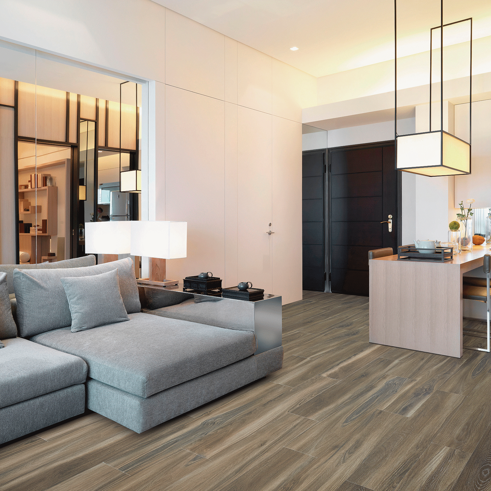 A living room with couches and lamps on the wall.