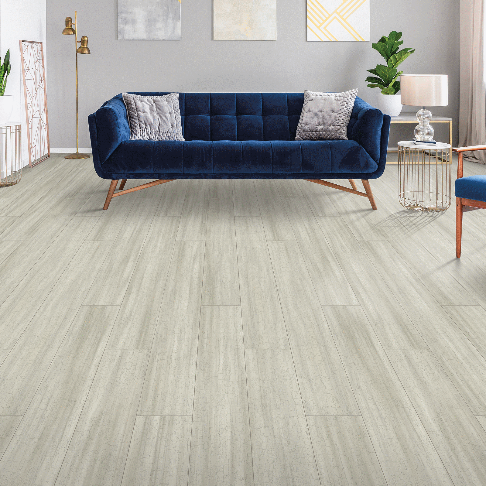 A living room with blue couch and white walls.