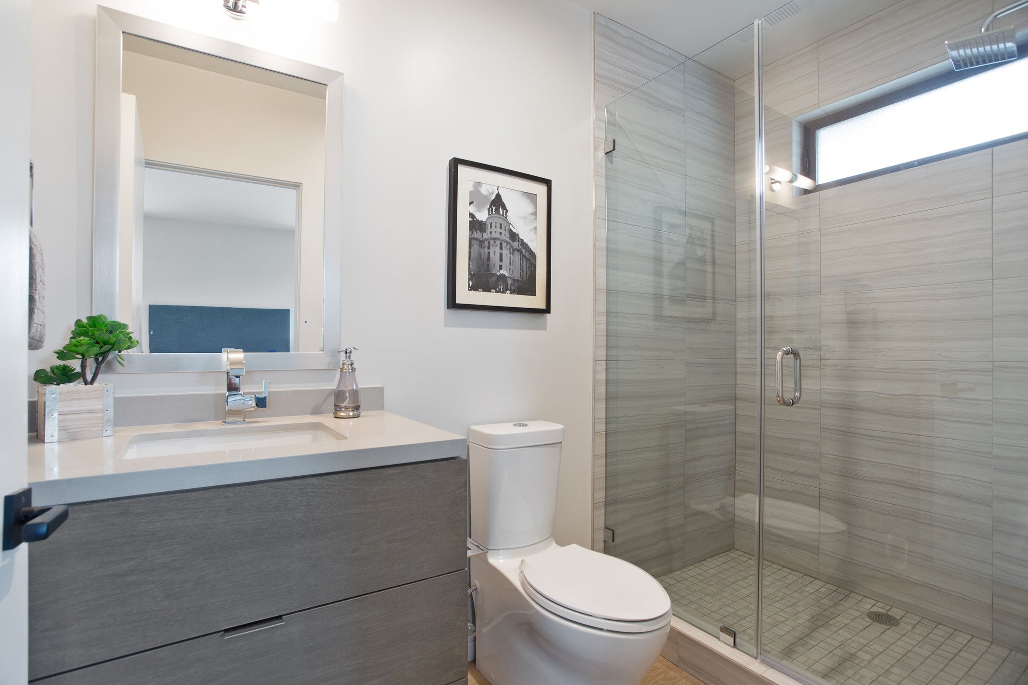 A bathroom with a toilet, sink and shower.