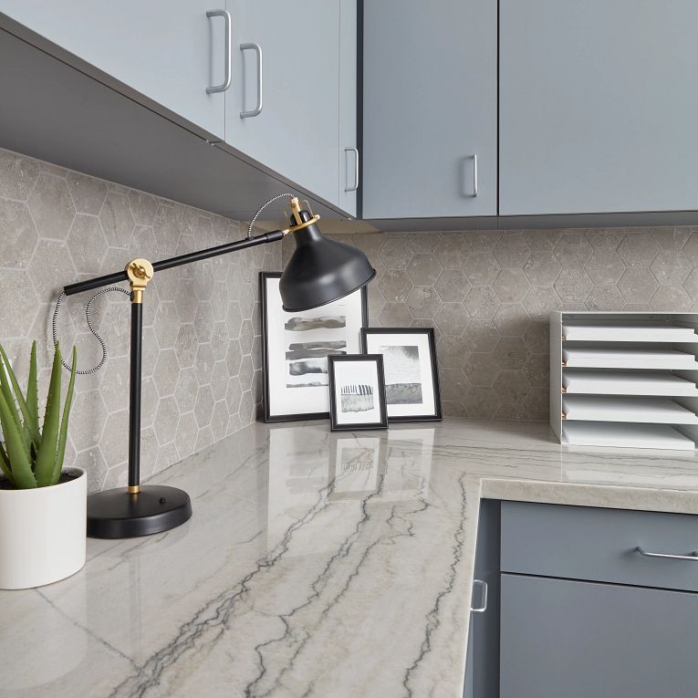 A counter with several pictures and a lamp on it.