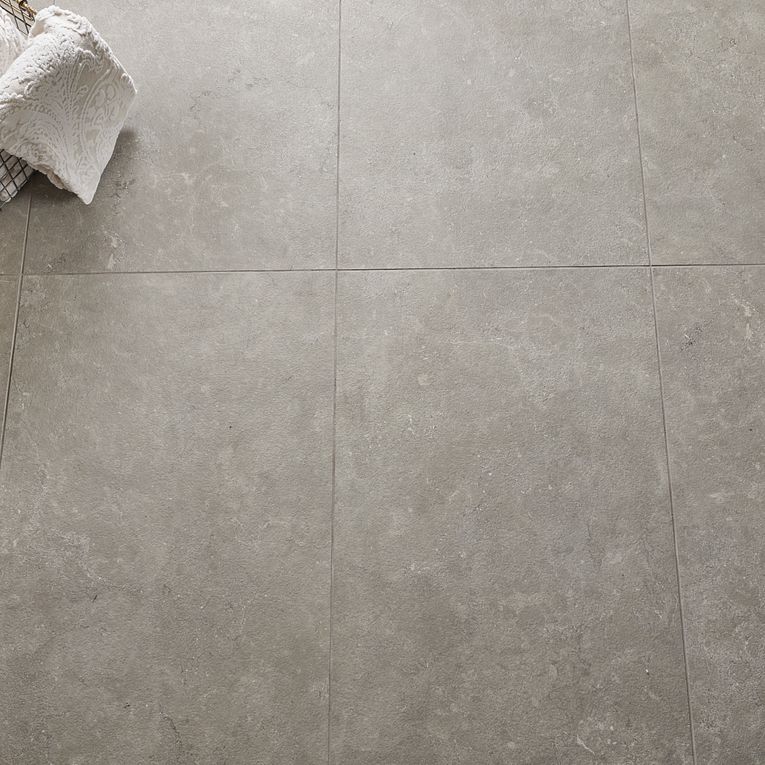 A white tile floor with some towels on it