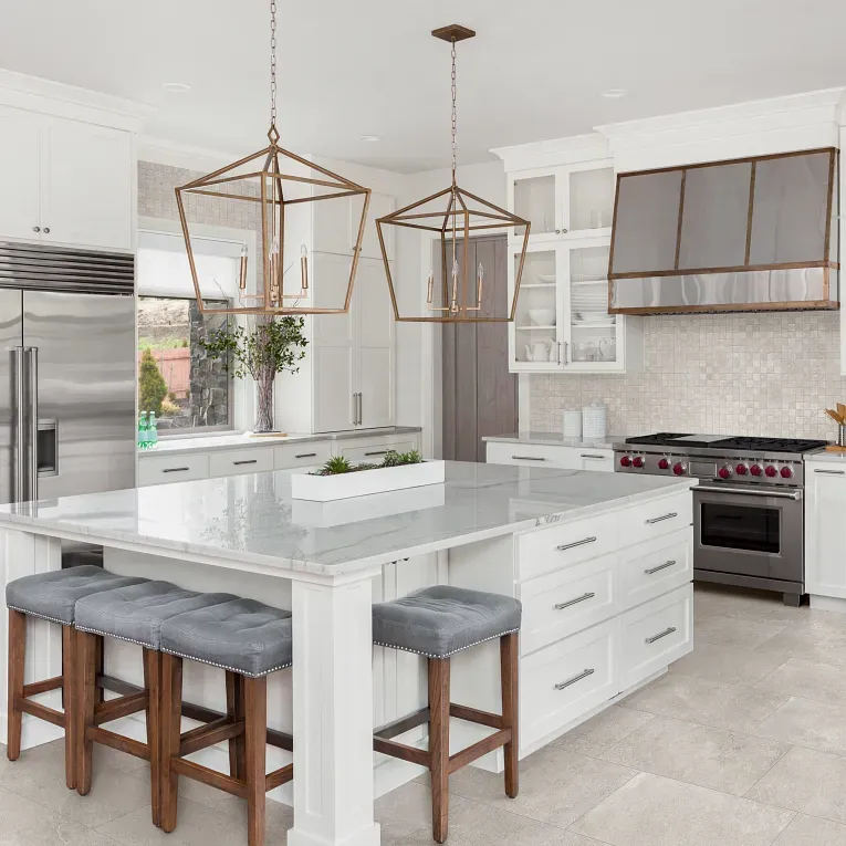 A kitchen with white cabinets and island in it
